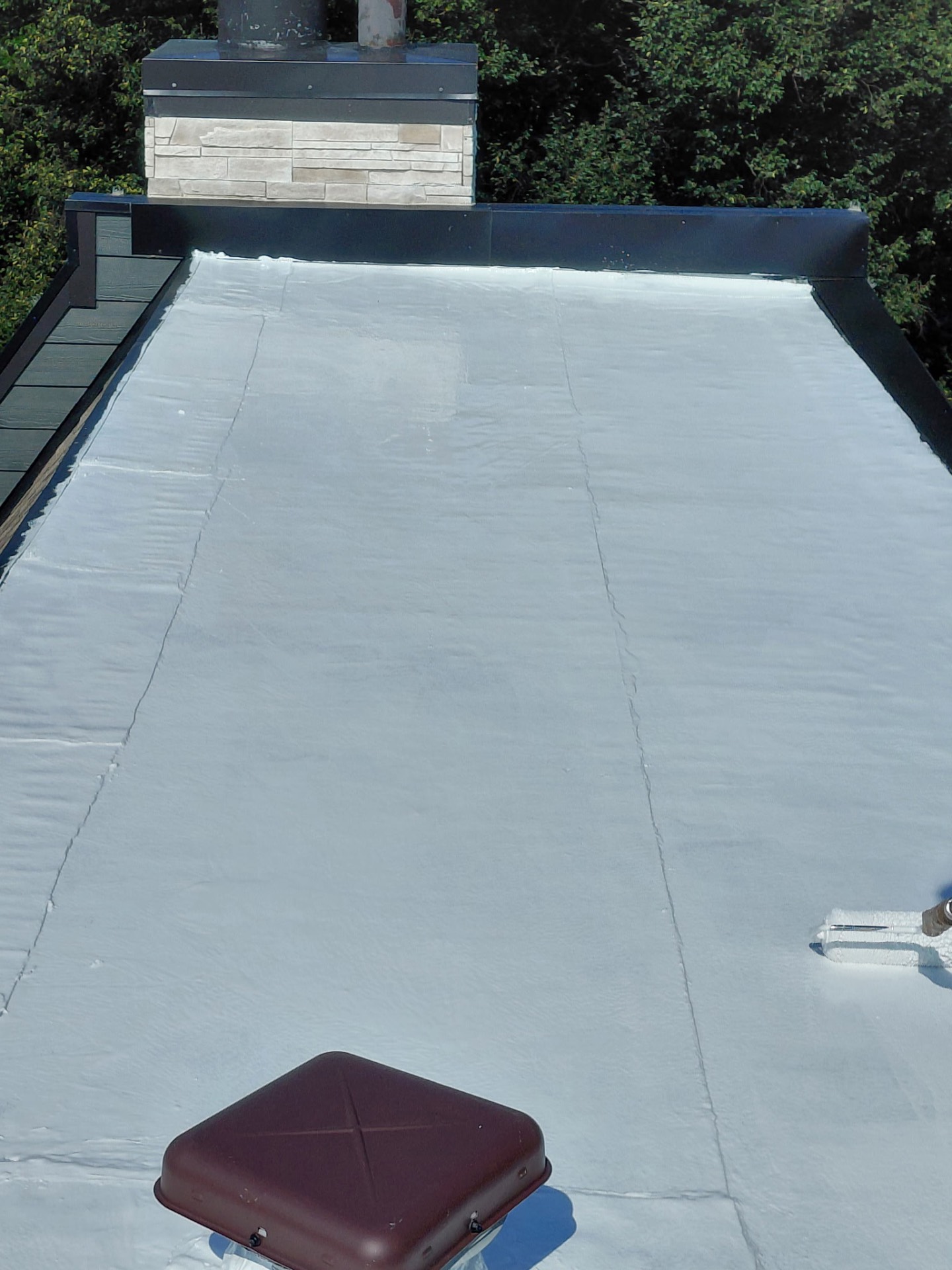 The same flat roof after a reflective white coating was applied